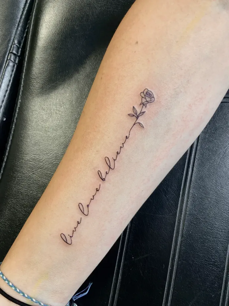 a live love believe message tattooed on an arm showcasing a fine line tattoo in Tampa