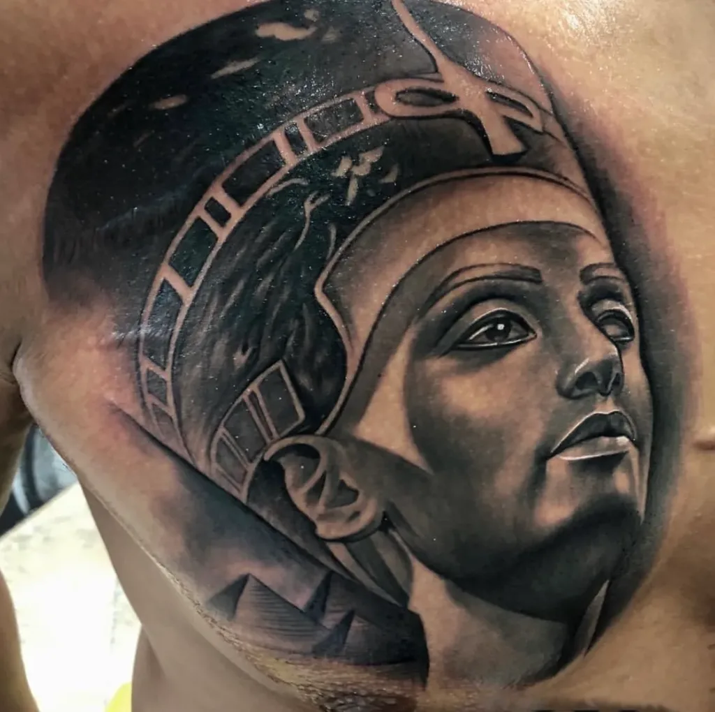 a tattoo of an Egyptian figure on a man's chest showcasing black and grey tattoo in Tampa, FL