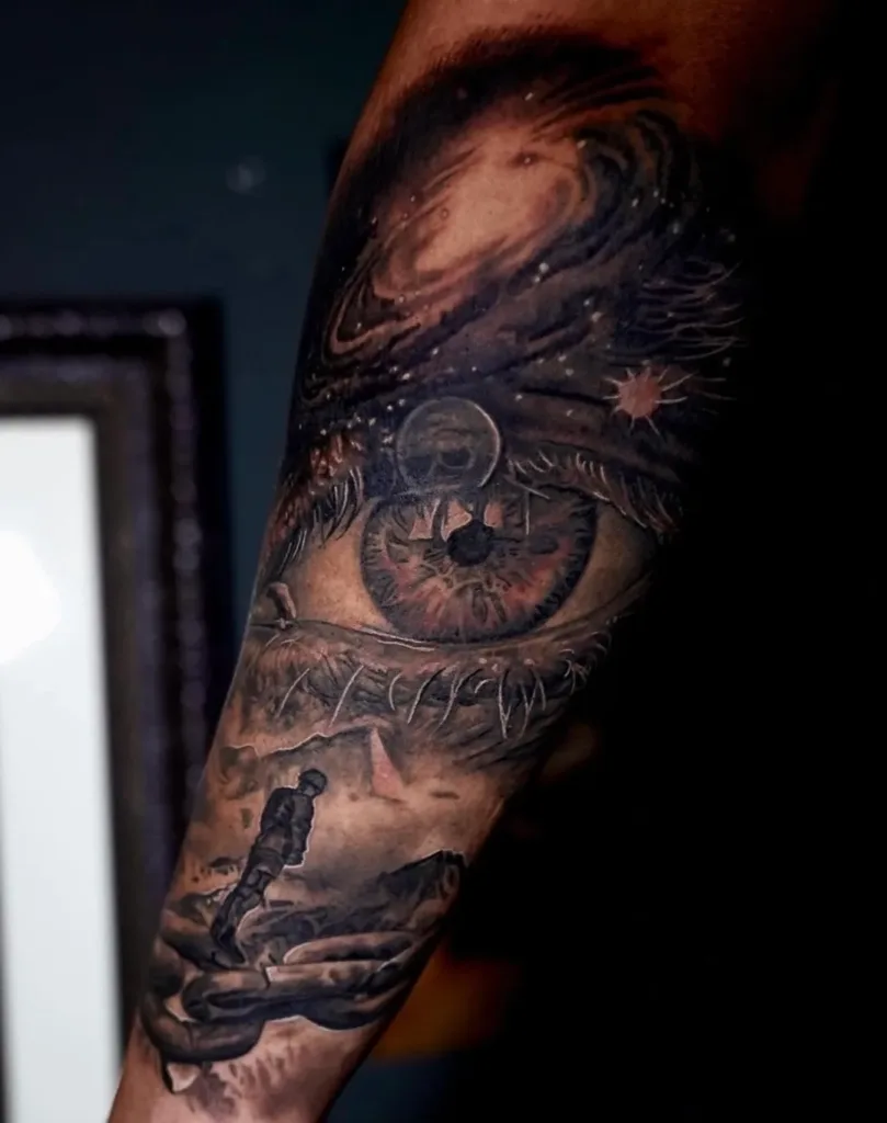an image of eye with a galaxy tattooed on a man's arm showcasing tattoo shops in Miami, FL